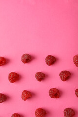 Flat lay composition with red juicy raspberries on a pink background