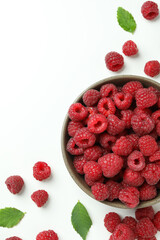 Red juicy raspberries in a bowl on a white background, space for text