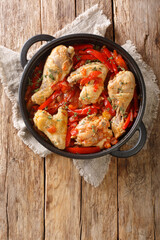 Basque Style Chicken with Peppers close up in the pan on the table. Vertical top view from above