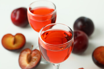Plum brandy shots and ingredients on white background