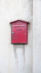Buzon de correo rojo metálico en pared blanca vieja