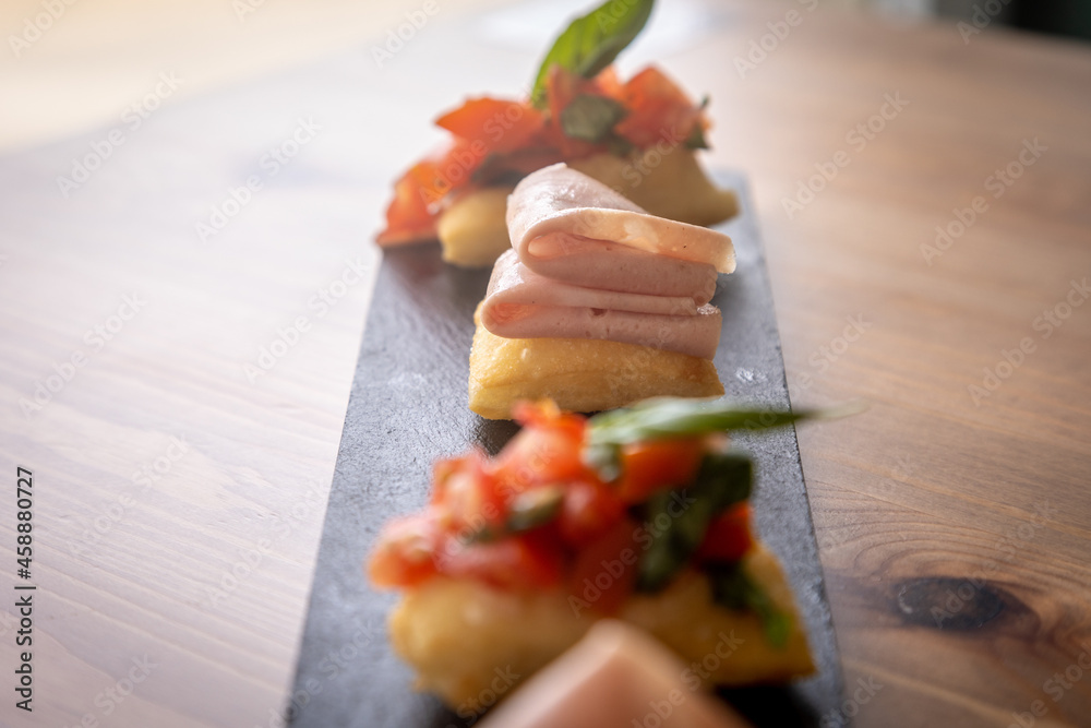 Sticker closeup shot of tasty bruschetta dish on a dark stone plate