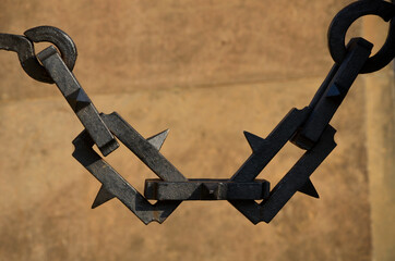 solid steel chain with rectangular mesh. there is a steel spike on each part. it resembles barbed...