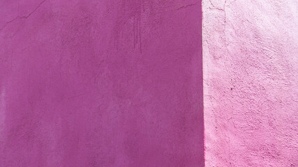 Esquina de paredes pintada de rosa magenta desgastada