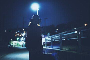 スーツケースを持って歩く女性の後ろ姿