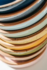 A large stack of ceramic cups in pastel colors.