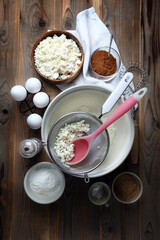 Homemade cheesecake ingredients: cottage cheese, eggs, coconut sugar, salt, corn starch, baking powder and spices on the table