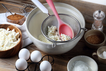 Homemade cheesecake ingredients: cottage cheese, eggs, coconut sugar, salt, corn starch, baking powder and spices on the table