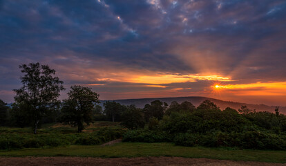 Dramatic September sunrise behind Leith hill from Holmbury Hill on the Surrey Hills, south east England