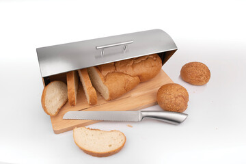 Bread bin. Kitchen ware. Fresh baked sesame buns in wooden  and steel box with bread knife