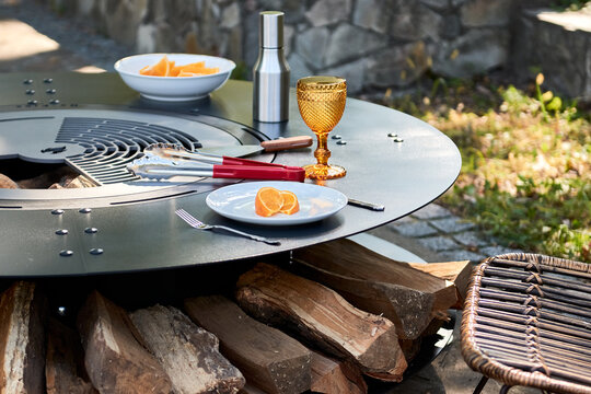 Kettle Grill Pit with Cast Iron Grid with flames . Round table-cooking surface. Hot BBQ on Backyard