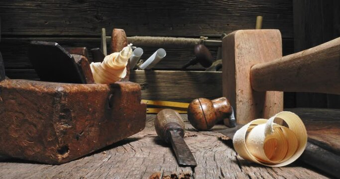 Tampers, chisels, planes in carpentry workshop. Vintage joinery workbench.