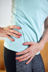 Woman with hip - stomach pain at home.