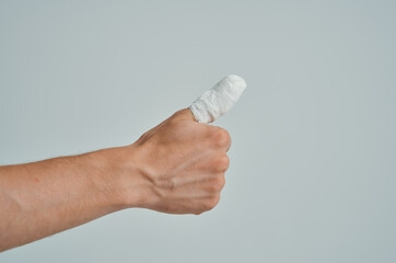 sick man in a white T-shirt with a bandaged hand isolated background