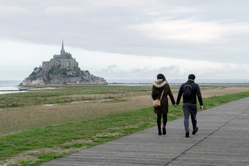 Young couple walking on Mont Saint-Michel hand in hand