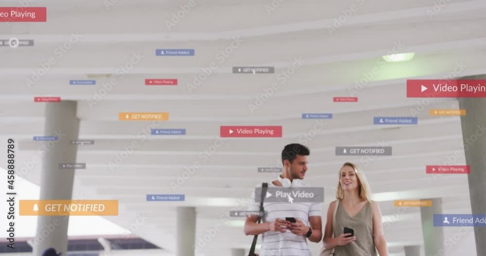 Wall mural Animation of social media icons floating over happy caucasian couple walking and using smartphones