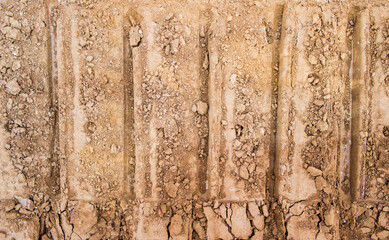 Dry soil texture and background. Brown soil background. Abstract ground. Natural abstraction. Clay. Ocher. Red sands. Pressed ground. Caterpillar tracks traces