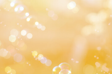 abstract blurry yellow holiday background with bokeh and particles