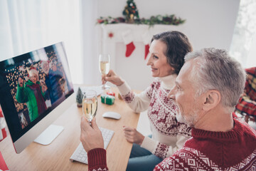 Photo of adorable sweet age couple dressed print pullovers talking modern device drinking white wine smiling indoors room home house