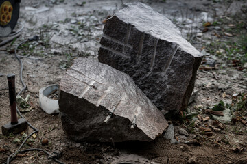 splitted granite boulder rock. Splitting with drilling holes and typing wedges. Then nailed them with hammer that makes stone crack in two pieces. Used in building industry and stonemasonry