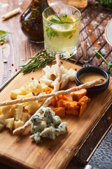 antipasti, different types of cheese on a wooden board with honey