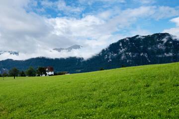 Beautiful green mountains landscape in Switzerland Alps. Small house