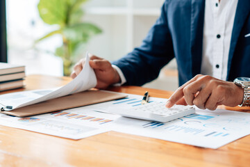 Close up of accountant or banker checking investment results, calculates financial savings, calculates annual taxes and economic concepts. Financial calculation concept.