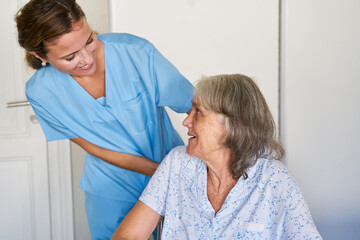 Junge Altenpflegerin kümmert sich fürsorglich um Seniorin