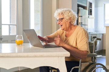 Seniorin im Rollstuhl am Laptop Computer beim Videochat
