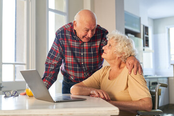 Glückliches Senioren Paar im Ruhestand sitzt am Laptop