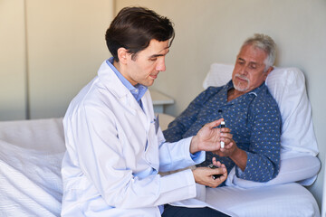 Obraz premium Altenpfleger misst sorgfältig den Blutzuckerspiegel von Senior