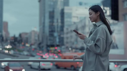 Korean woman using cell phone while walking outdoors - Powered by Adobe