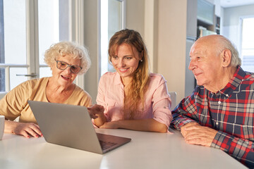 Tochter hilft Senioren Eltern mit Laptop Computer