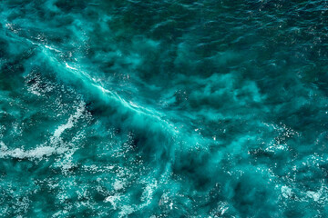 Aerial view to seething waves with foam. Waves of the sea meet each other during high tide and low tide