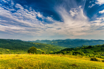 Obraz premium Autumn mountain landscape - yellowed and reddened autumn trees combined with green needles and blue skies. Colorful autumn landscape scene in the Romanian Carpathians. Panoramic view.