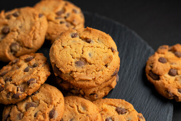 Fresh crispy chocolate cookies on a dark table