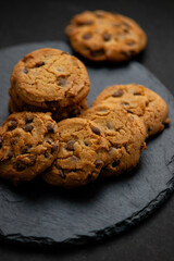 Fresh crispy chocolate cookies on a dark table