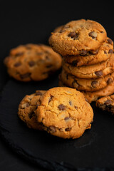 Fresh crispy chocolate cookies on a dark table