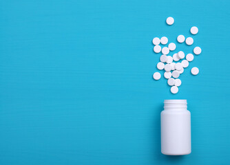 Pills, tablets and bottle on blue background.