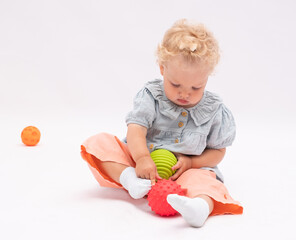 Pretty  baby girl plays with colorful balls