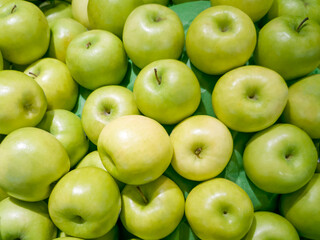 Close-up photo. Pile of green apples. The freshness of the fruit. Nature background and healthy food. Vitamins, seasonal vegetables and fruits.