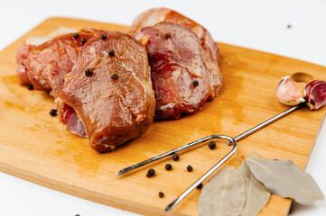 marinated pork tenderloin with spices. On a wooden board