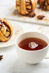 Fresh vegan cinnamon buns on marble board and white marble table