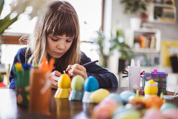 Girl painting easter eggs 
