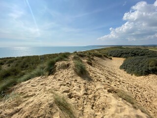 Camber sands East Sussex UK - view of Camber Sand dunes with sky and sea dunes held together with...