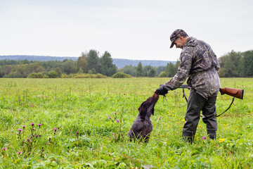 the hunter takes the downed crake from the dog