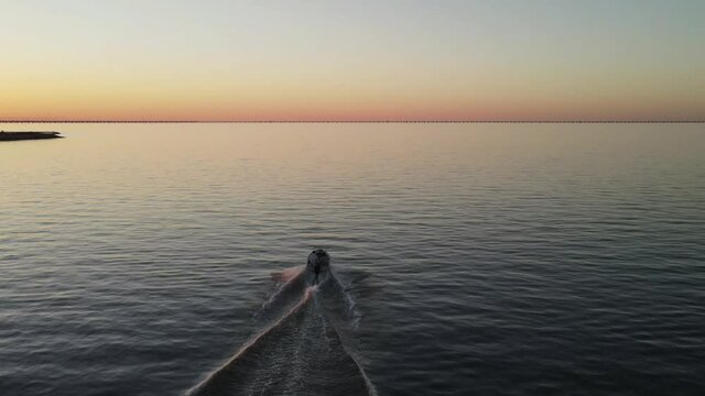 Speedboat Speeding On Calm Waters Leaving Wake Behind During Sunset. - aerial rear