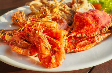 Grilled seafood platter with crab and prawns with garlic, selective focus.