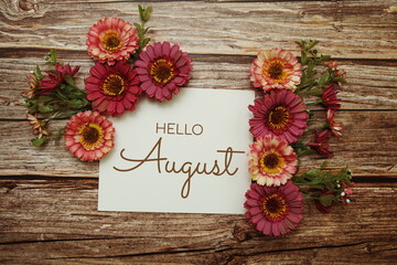 Hello August typography text with flowers on wooden background
