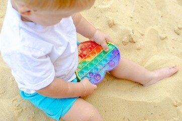 A child plays with a popit toy, simple dimple